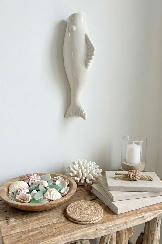 Vase murale céramique blanche poisson au dessus d'une table d'appoint style coastal chic